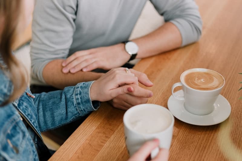 Two people sharing a supportive moment over coffee